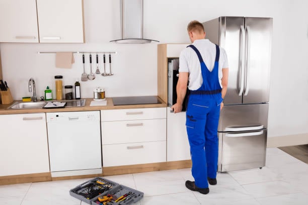 Technicus herstelt een ingebouwd keukentoestel bij de klant thuis