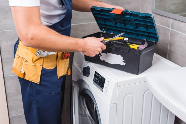 Technicus voert onderhoud uit aan een wasmachine